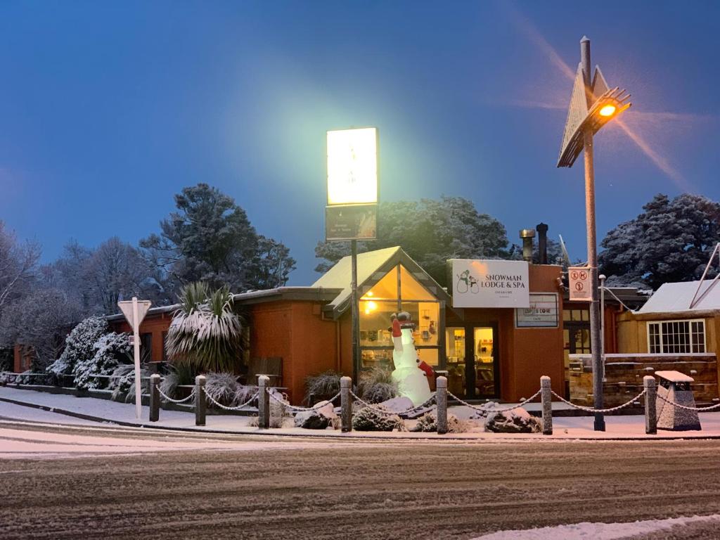 un magasin avec un bonhomme de neige devant un moulin à vent dans l'établissement Snowman Lodge and Spa, à Ohakune