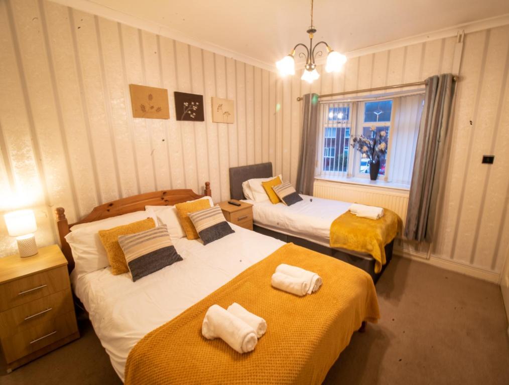 um quarto de hotel com duas camas e uma janela em Dryden House em Chesterfield