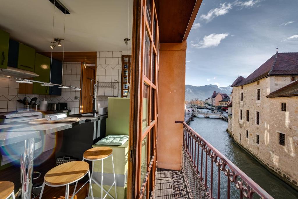 a balcony with a view of a river at Le Balcon du Palais de l'Isle - Aprtement 4 with stunning views in Annecy