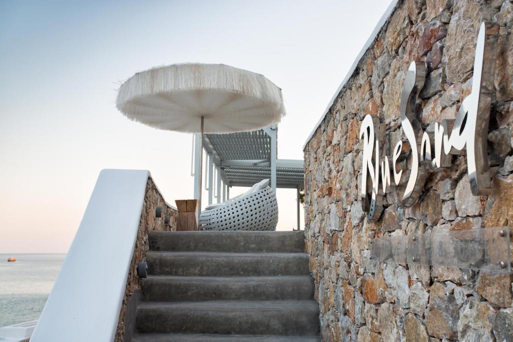 a staircase leading up to a building with an umbrella at Blue Sand Boutique Hotel & Suites in Agali