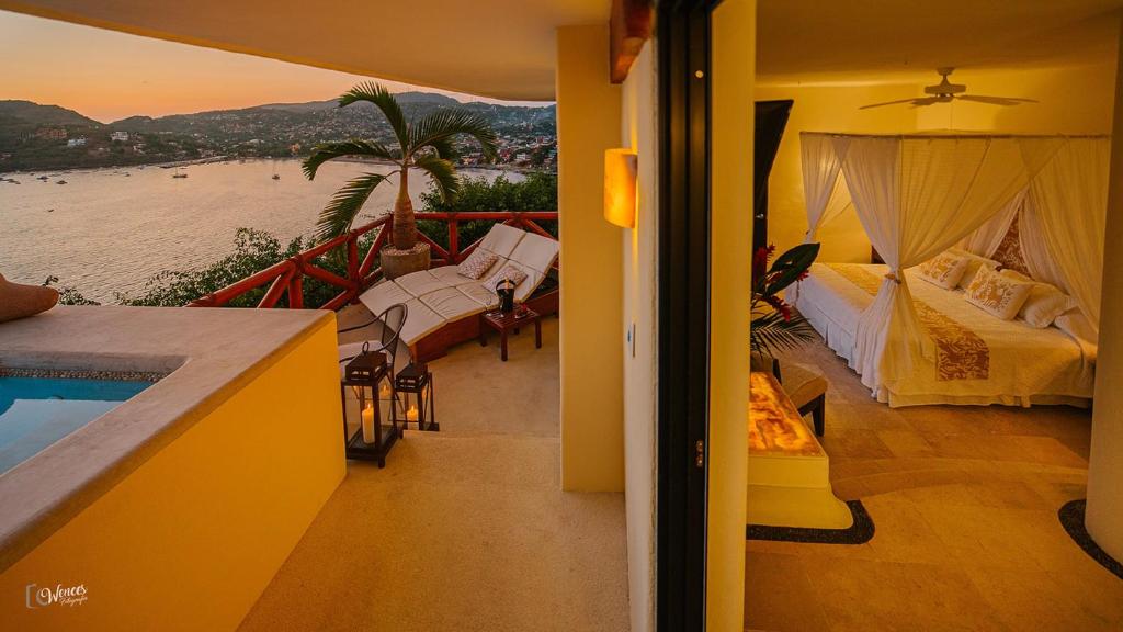 a room with a balcony with a bed and a pool at Tentaciones Hotel & Lounge Pool - Adults Only in Zihuatanejo