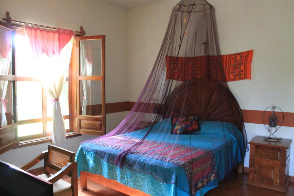 a bedroom with a bed and a canopy at Hotel El Molino in Río Verde