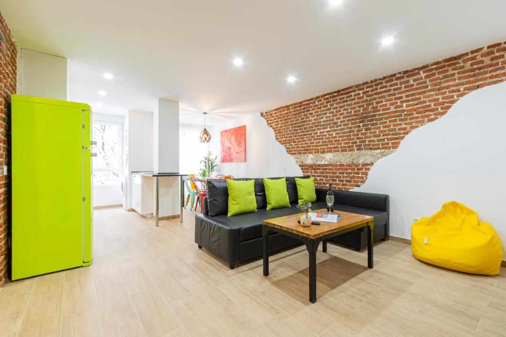マドリードにあるEver House - IFEMA Canillasのソファとレンガの壁のあるリビングルーム