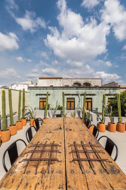 ein Holztisch mit Stühlen vor einem Gebäude in der Unterkunft Casa Olié in Oaxaca de Juárez
