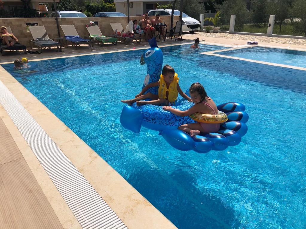 eine Gruppe Kinder, die auf einem Floß im Pool reiten in der Unterkunft "HOLIDAY" apartments & rooms in Ulcinj