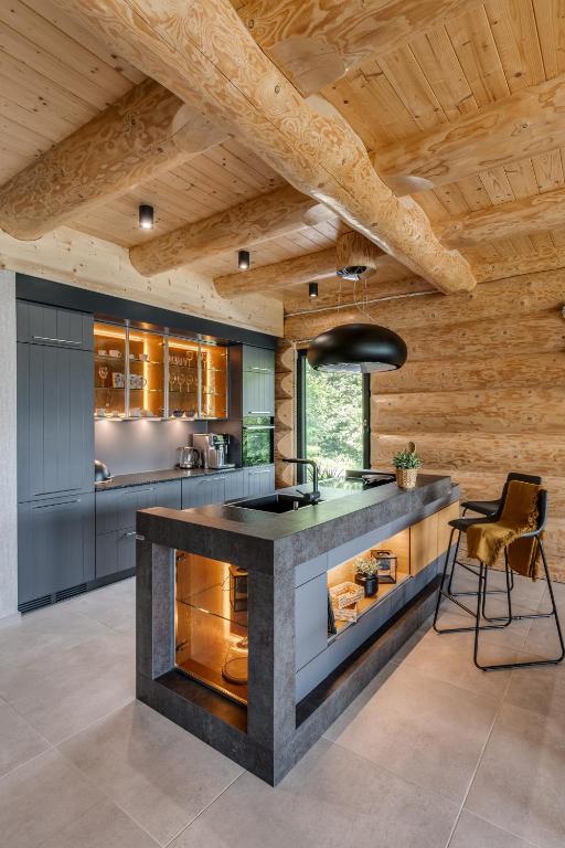 a kitchen with a large island in a room with wooden ceilings at Międzybrodzie Bialskie Apartamenty Nowy Świat in Międzybrodzie Bialskie