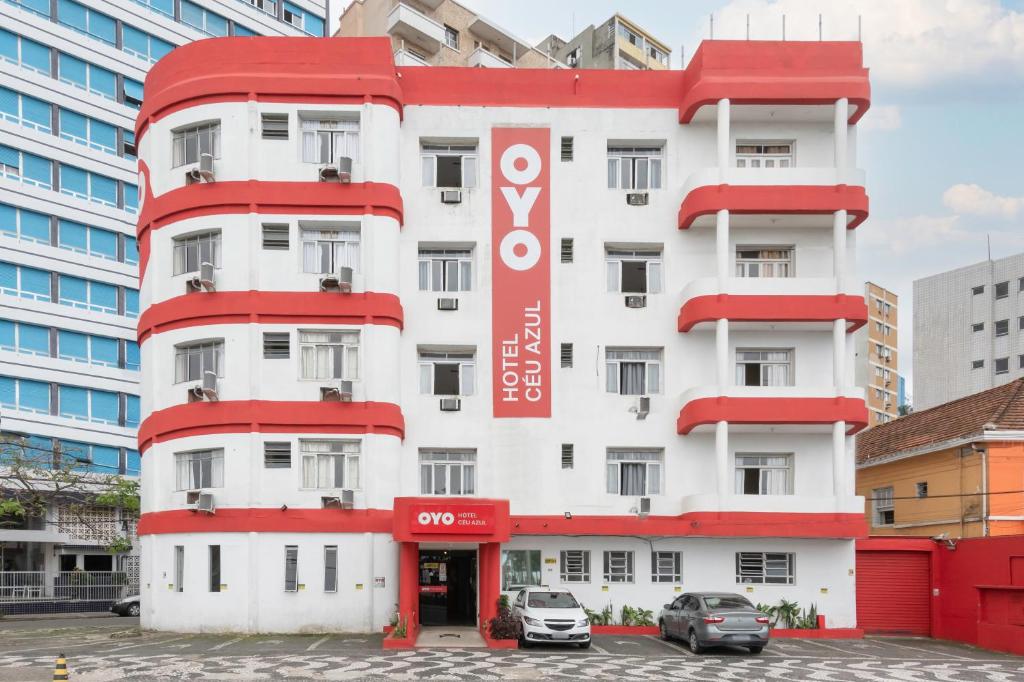 a white and red building with a sign on it at OYO Hotel Céu Azul, São Vicente in São Vicente