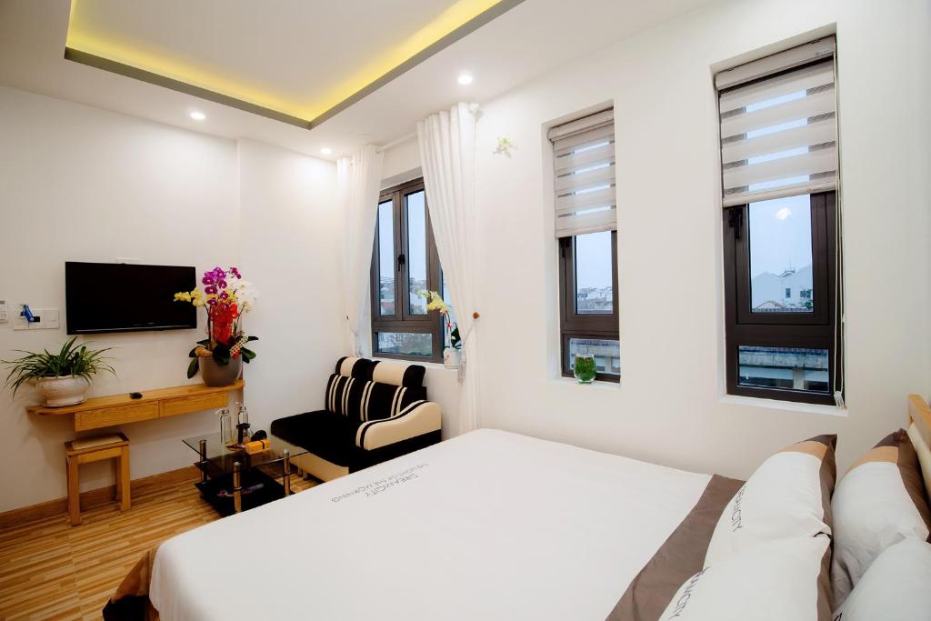 Habitación de hotel con cama y TV en Hoian Royal Villa, en Hoi An