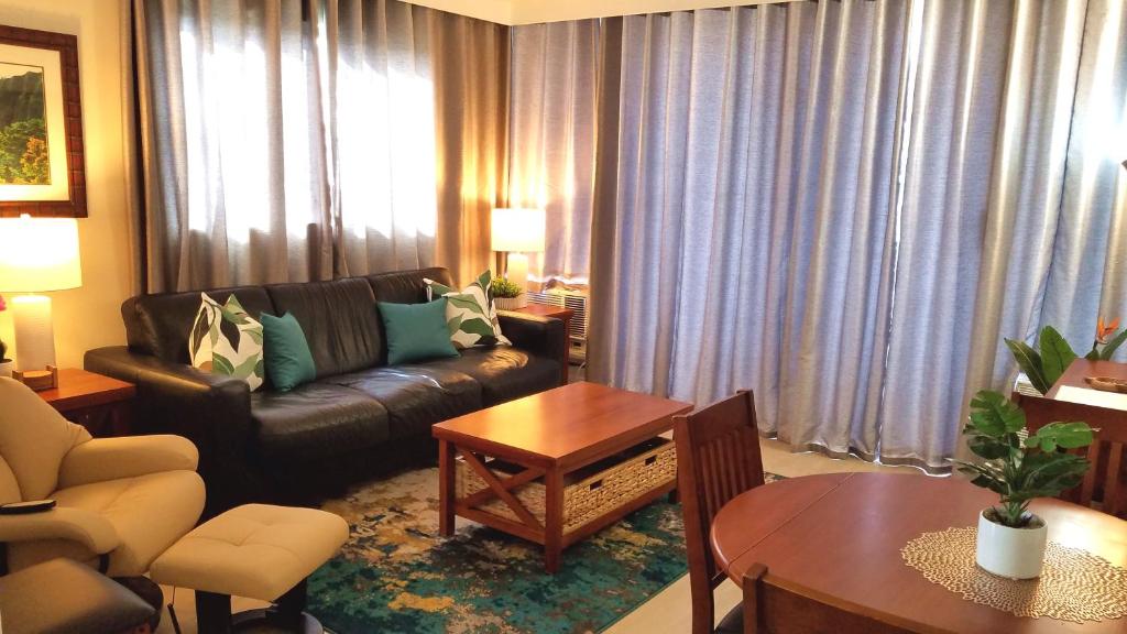 een woonkamer met een bank en een tafel bij Waikiki Kuhio 1-bedrm Apt, Ocean view, Free Parking & Wifi in Honolulu