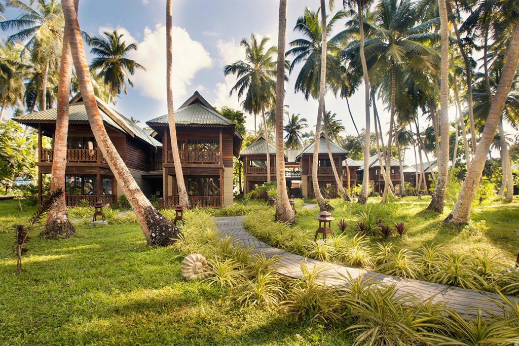 a resort with palm trees in front of a building at Sea Shell Resort & Spa, Havelock in Havelock Island