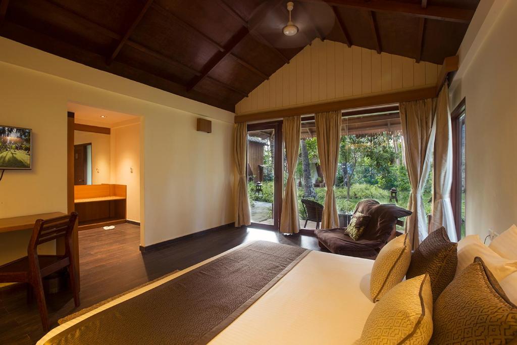a bedroom with a large bed and a living room at Sea Shell Resort & Spa, Havelock in Havelock Island