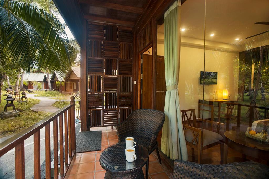 a balcony of a house with a table and chairs at Sea Shell Resort & Spa, Havelock in Havelock Island