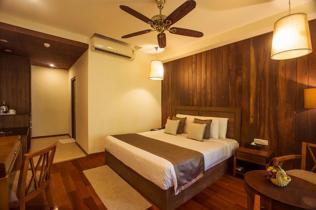 a bedroom with a bed and a table and a ceiling fan at Sea Shell Resort & Spa, Havelock in Havelock Island