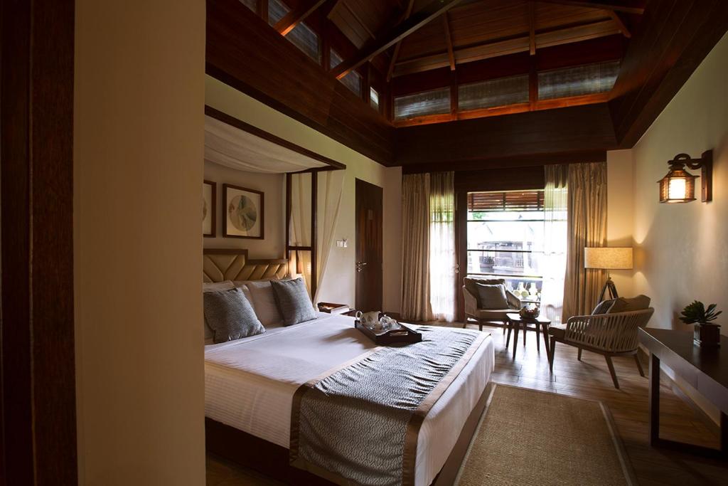 a bedroom with a large bed and a living room at Sea Shell Resort & Spa, Havelock in Havelock Island