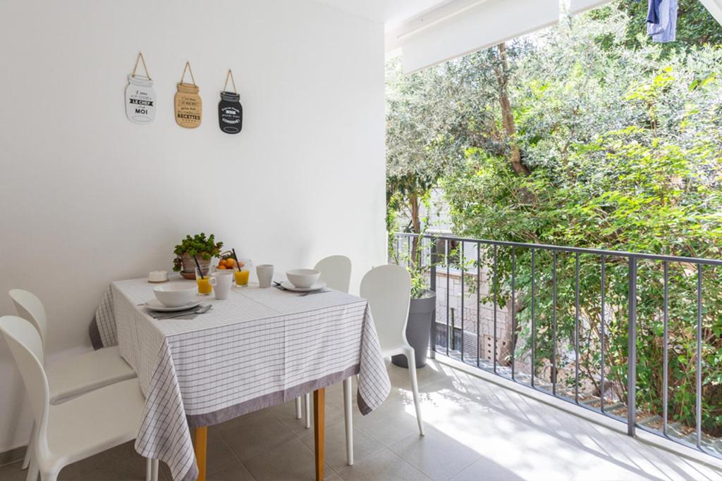 uma sala de jantar branca com uma mesa e cadeiras e uma varanda em Luxury BonBon next to Banje beach and Old Town, great location em Dubrovnik