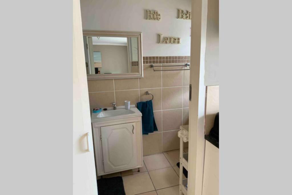 bagno con lavandino e specchio di Cozy guest suite with private access a Roodepoort