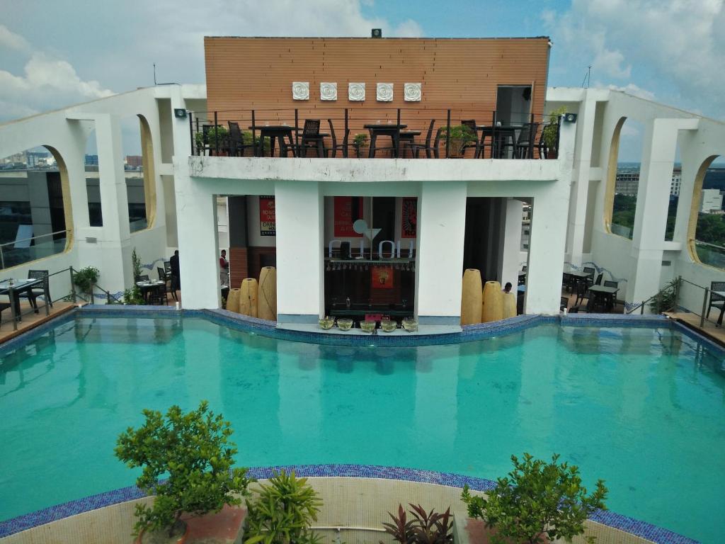 a large swimming pool in front of a building at Hotel Senses in Kolkata