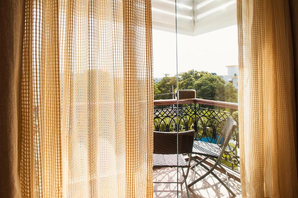 a view of a balcony with a chair and a window at Sea Shell Port Blair in Port Blair