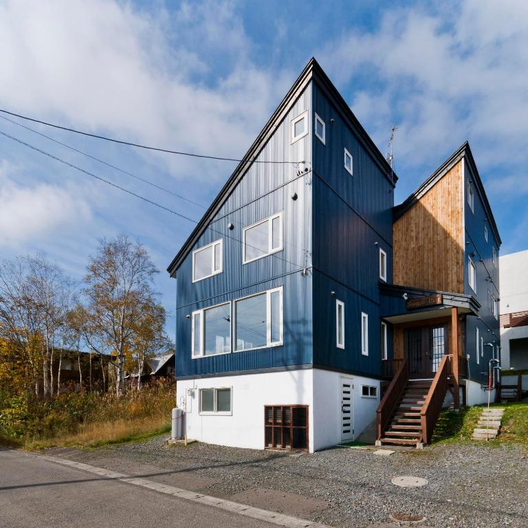 a house with a blue and white facade at Sugarpot in Kutchan