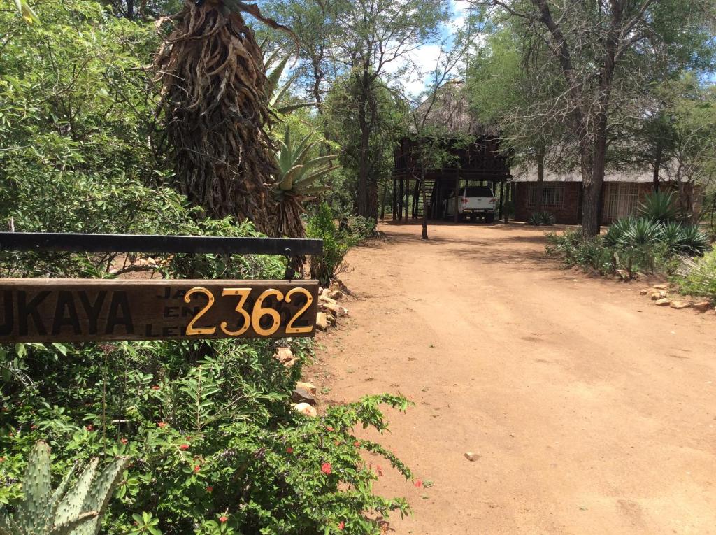 um sinal numa cerca ao lado de uma estrada de terra batida em Swartwitpens 2362 em Marloth Park