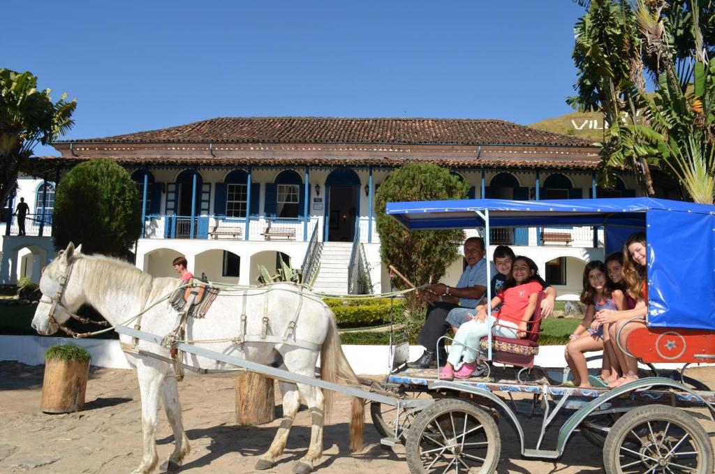 un groupe de personnes voyageant en calèche tirée par des chevaux dans l'établissement Hotel Fazenda Villa-Forte, à Engenheiro Passos