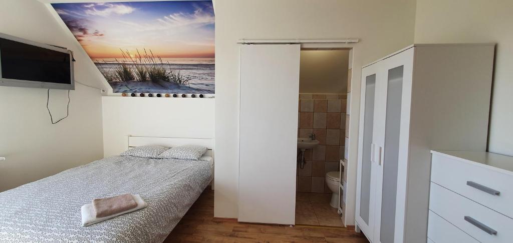 a small bedroom with a bed and a bathroom at Komodor - OZONOWANE pokoje gościnne in Ustronie Morskie