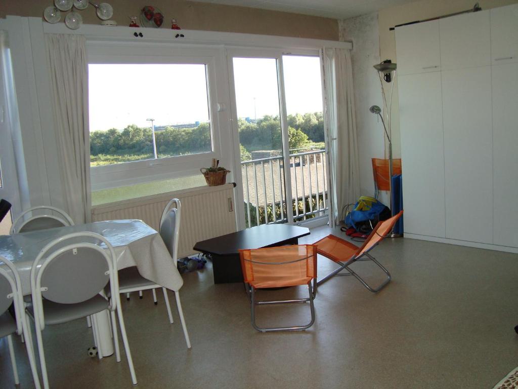 comedor con mesa y sillas y balcón en Studio Heist, en Knokke-Heist