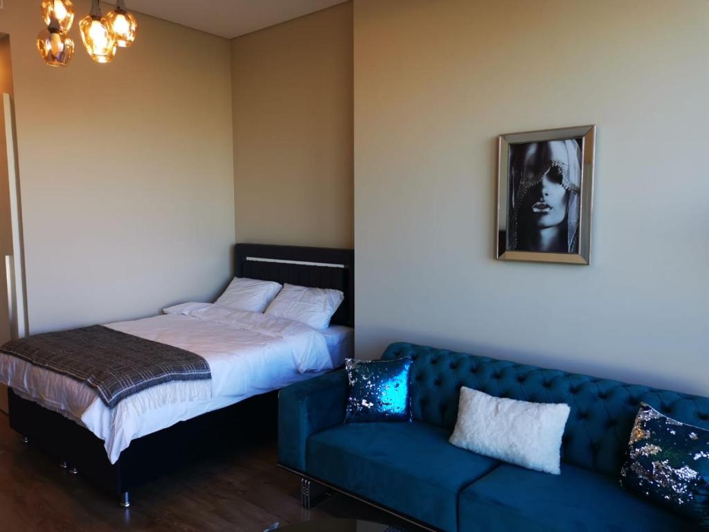 ein Schlafzimmer mit einem blauen Sofa und einem Bett in der Unterkunft Metropol Ataşehir in Istanbul