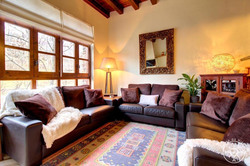 a living room with couches and a couch and a mirror at CASA AIGUAMOIX de Alma de Nieve in Tredós