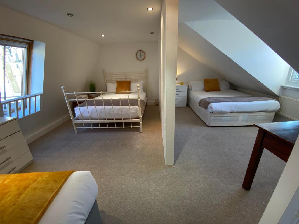 una camera mansardata con 2 letti e una scala di Central Townhouse & Terrace a Brighton & Hove