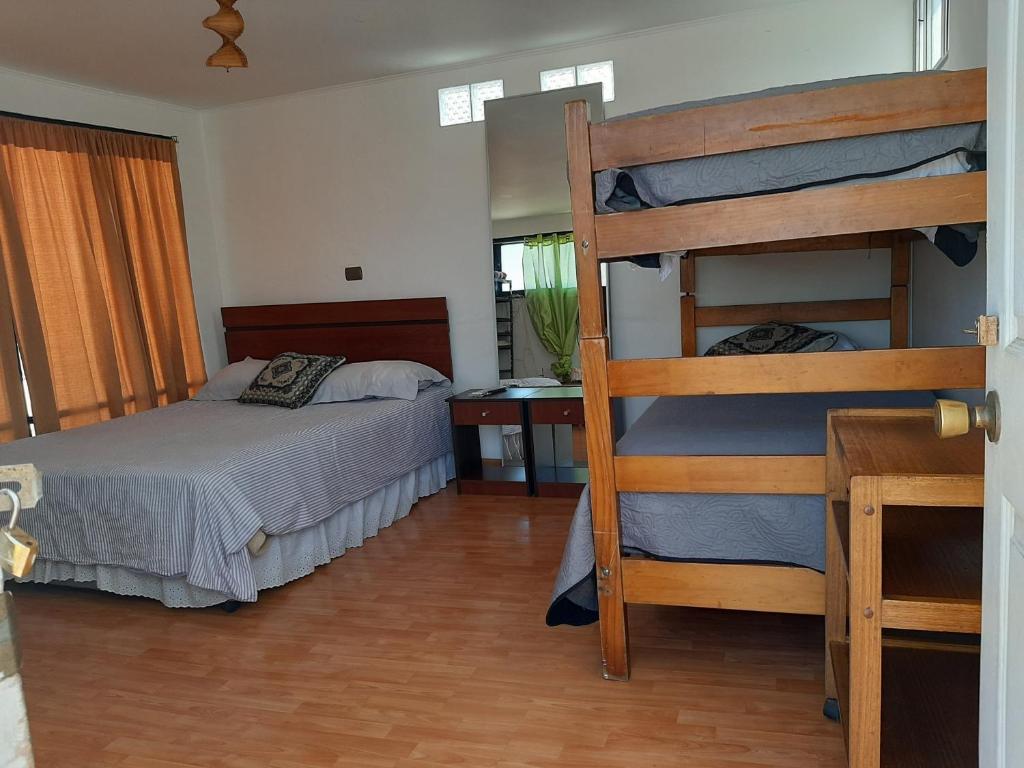 a bedroom with two bunk beds and a desk at Hostal Pampaloja in Antofagasta