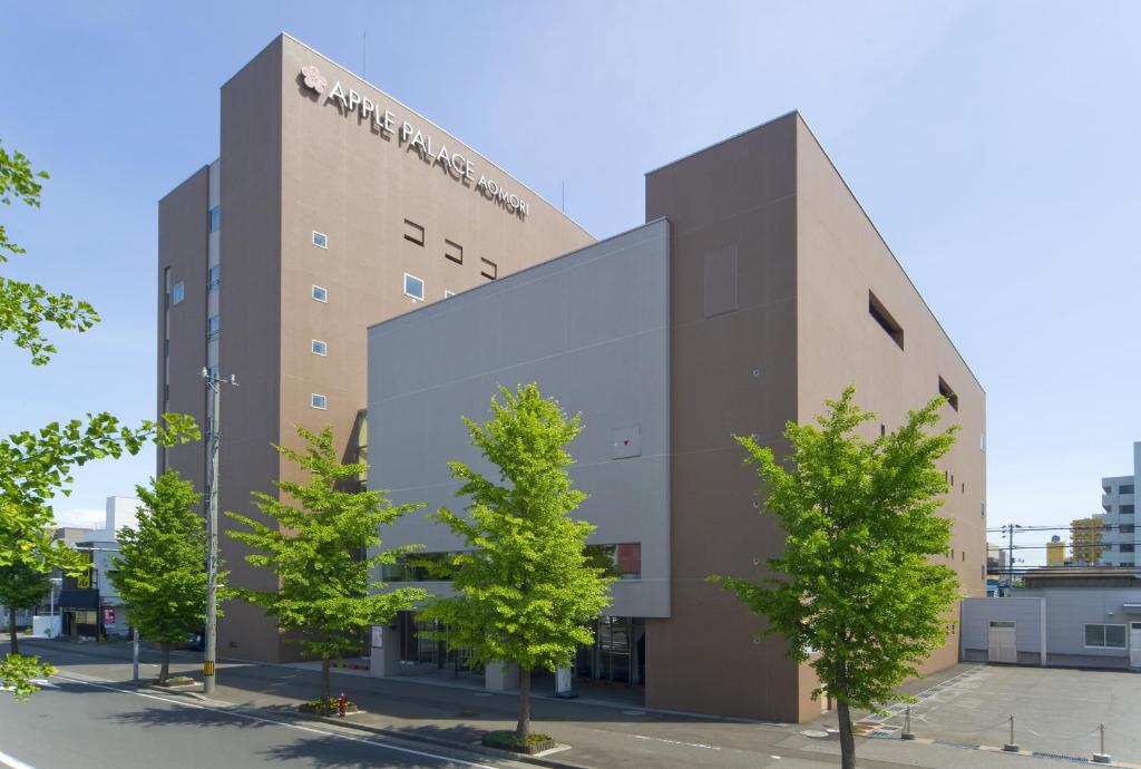 a building with trees in front of it at Apple Palace Aomori in Aomori