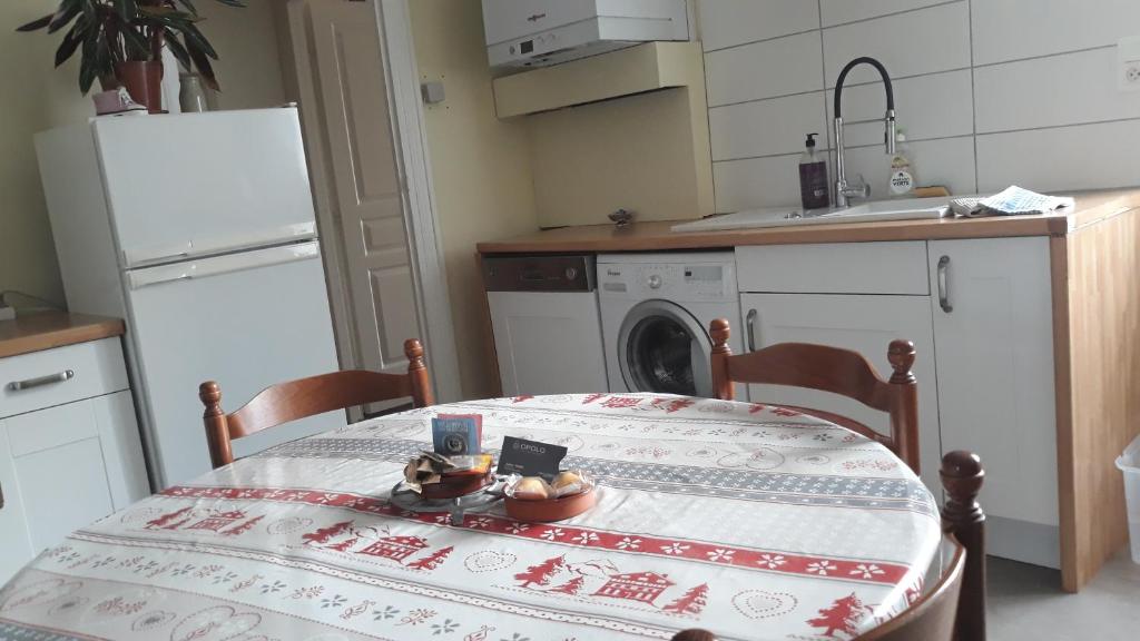 a kitchen with a table and a kitchen with a washing machine at appartement "les goumis" in Baccarat