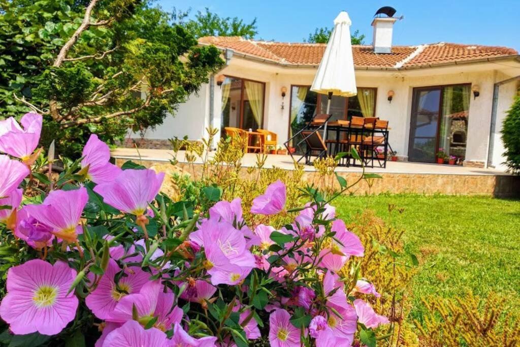 a house with pink flowers in the yard at Guesthouse Oasis-Shabla in Shabla