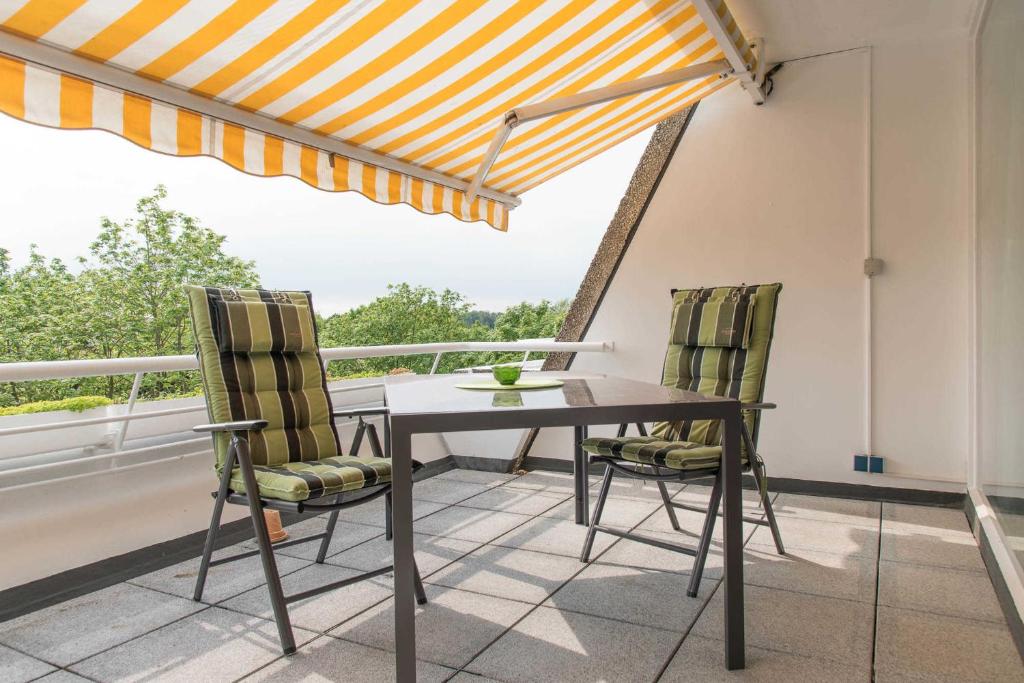 ein Esszimmer mit einem Tisch und Stühlen auf dem Balkon in der Unterkunft Ferienwohnung Saphir in Schilksee