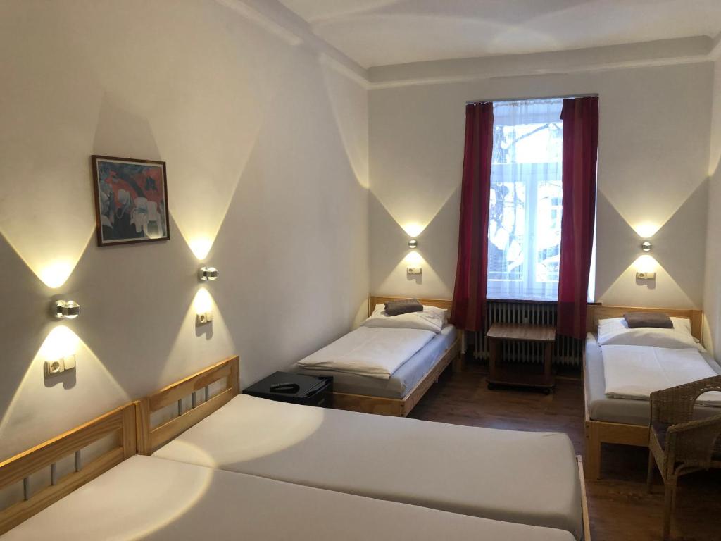 a hotel room with two beds and a window at Hotel Pension Schmellergarten in Munich