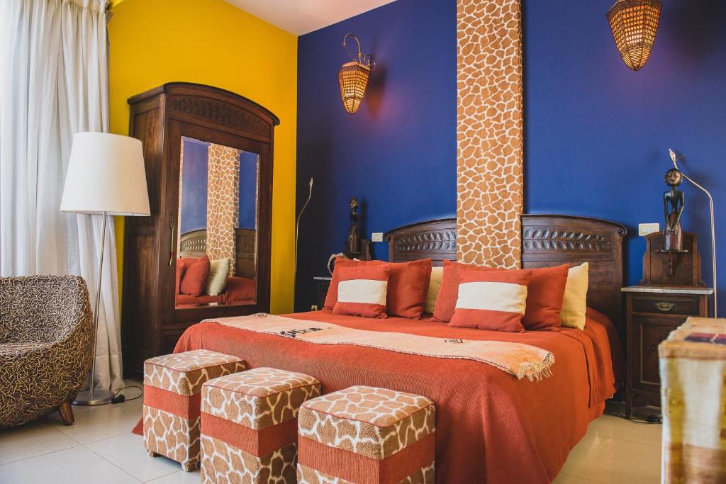 1 dormitorio con 1 cama con paredes azules y amarillas en Los Muelles Boutique Hotel, en Carmelo