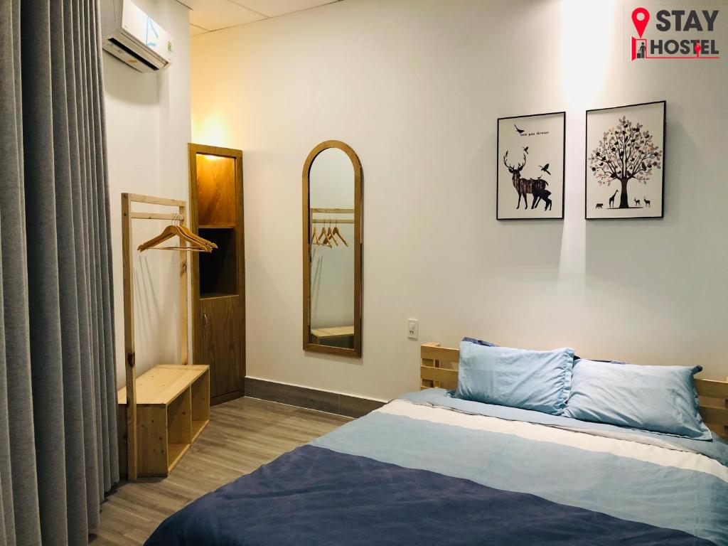 um quarto com uma cama e um espelho na parede em STAY hostel 2 - 350m from the ferry em Rạch Giá