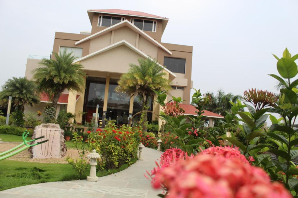 a building with a lot of flowers in front of it at 7 Seasons resort & Spa in Jamnagar