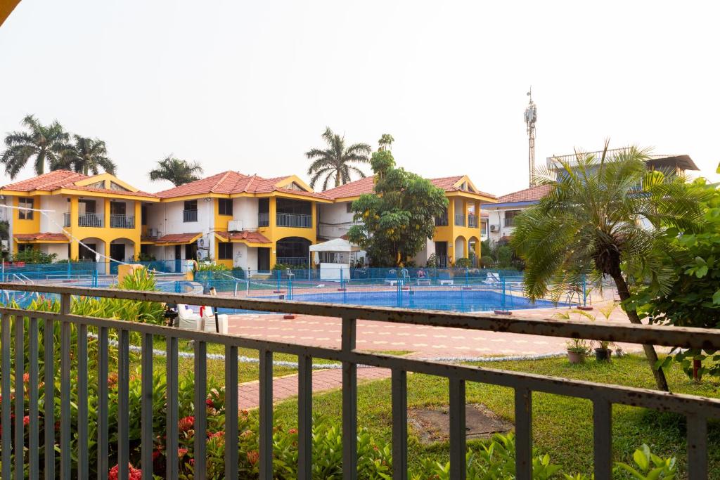 eine Reihe gelber Häuser mit einem Pool in der Unterkunft Villa Knox in Benaulim