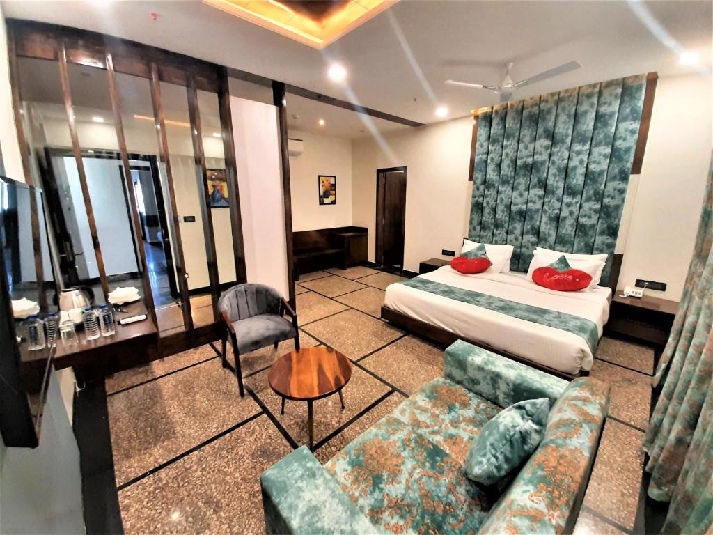 a hotel room with a bed and a couch at Suvin Residency with Rooftop Swimming Pool in Udaipur