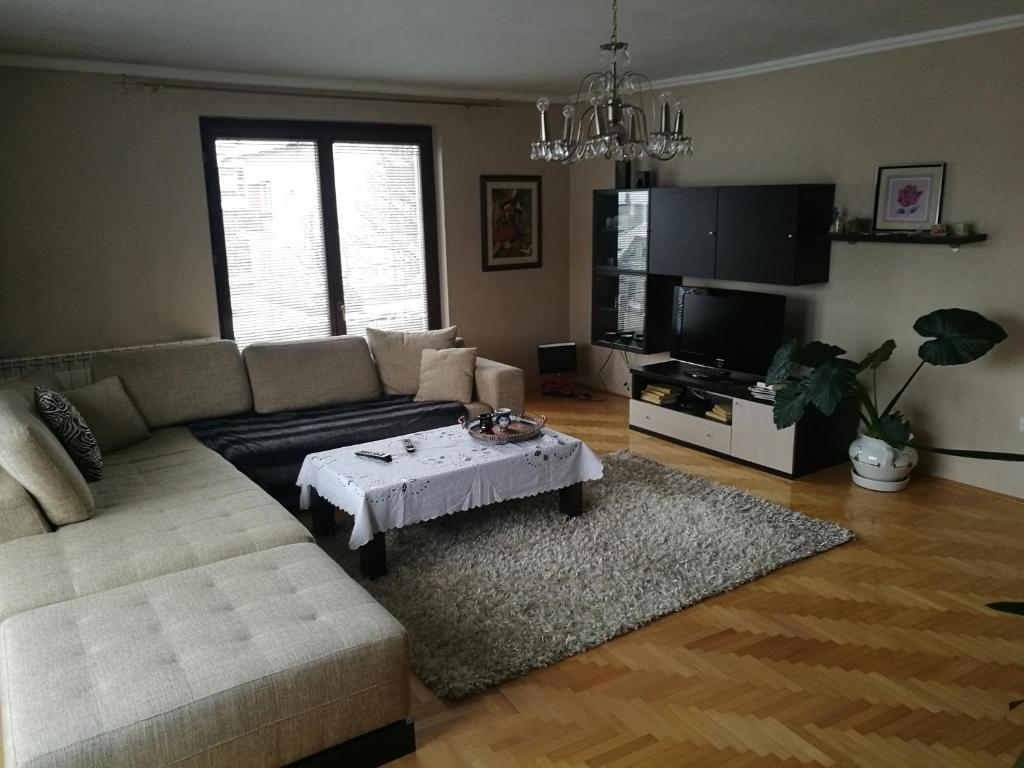sala de estar con sofá y mesa en Apartment Imamović, en Vogošća