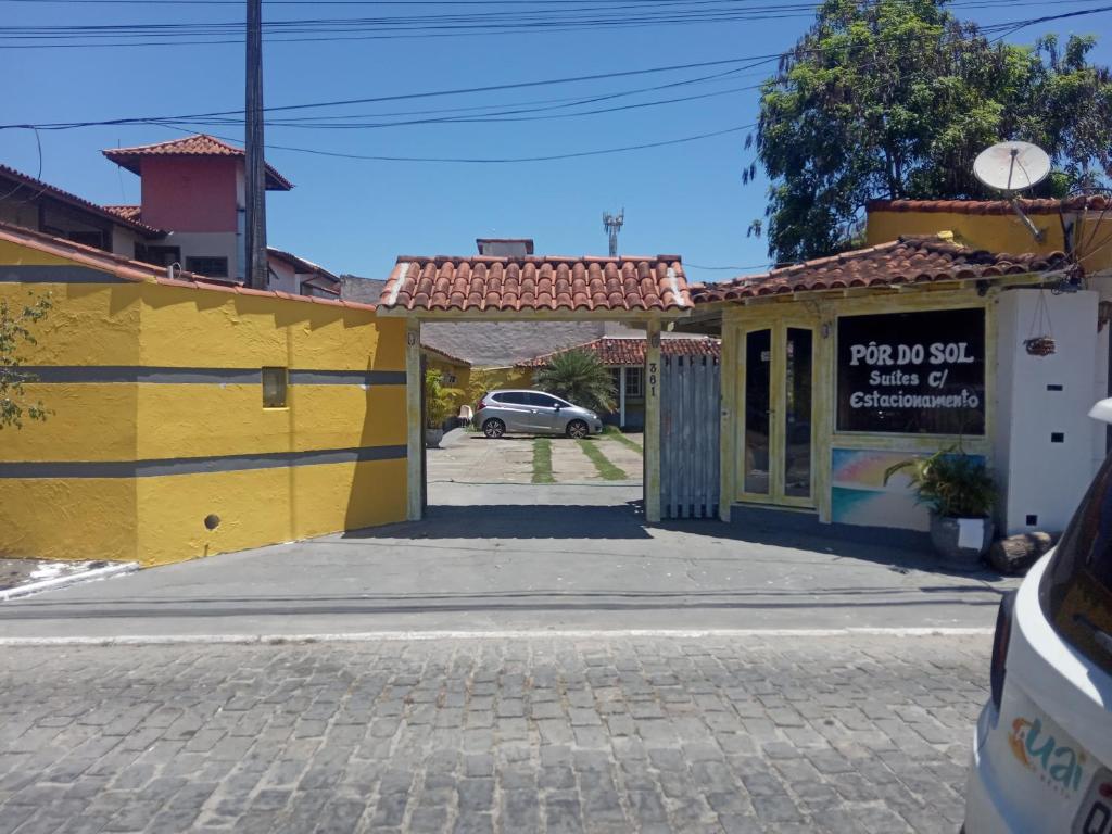a street in a town with yellow buildings at Suites por do Sol in Búzios