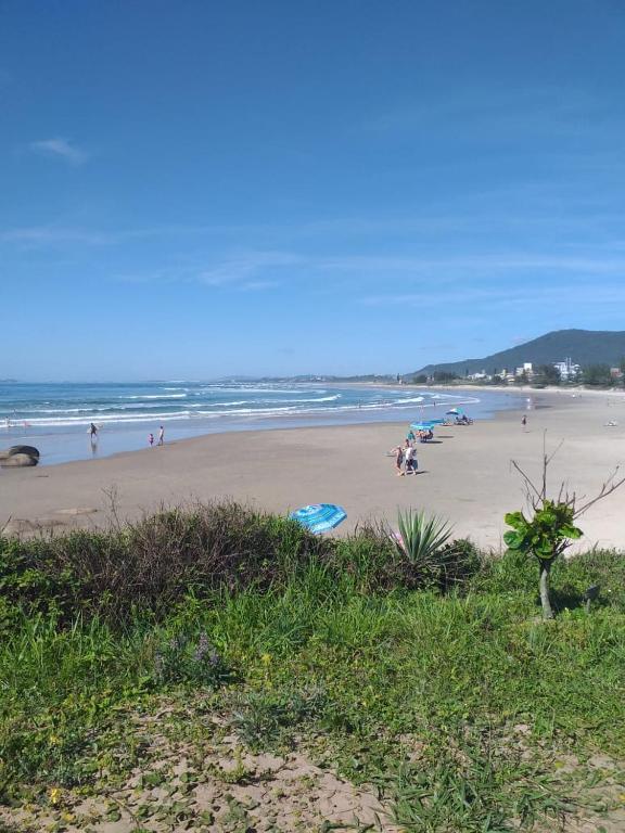 a group of people on a beach near the ocean at Apartamento em Imbituba, praia da Vila in Imbituba