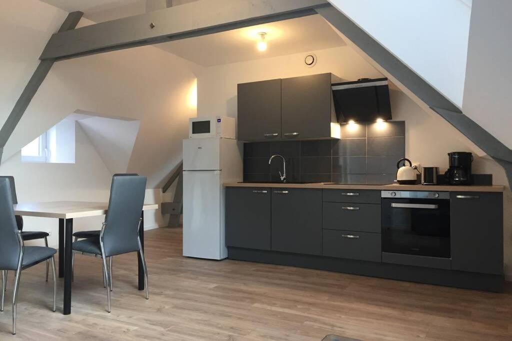a kitchen and dining room with a table and chairs at APPARTEMENT T2 in Saint-Brieuc