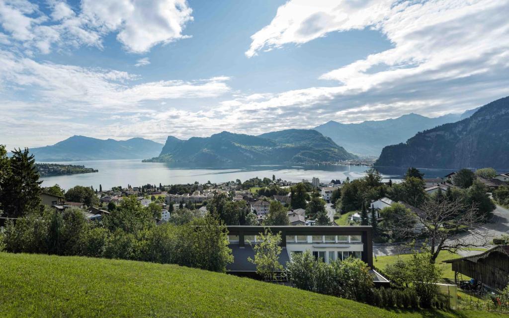 een huis op een heuvel met uitzicht op een meer bij Villa Ysara, 7 Bedroom Pool Villa with lake Lucerne View in Luzern