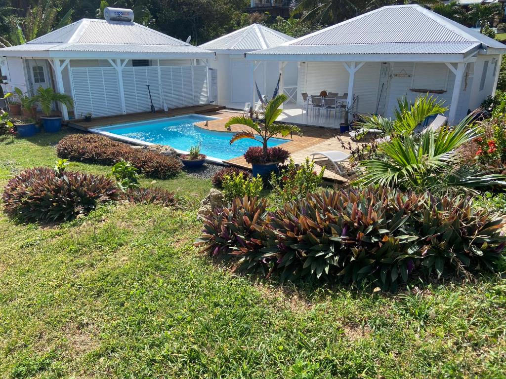 a backyard with a swimming pool and a house at le ti bleu in Le Moule