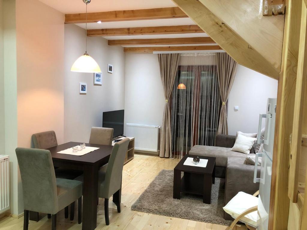 a living room with a table and a couch at Apartmani Sredojevic in Kaludjerske Bare