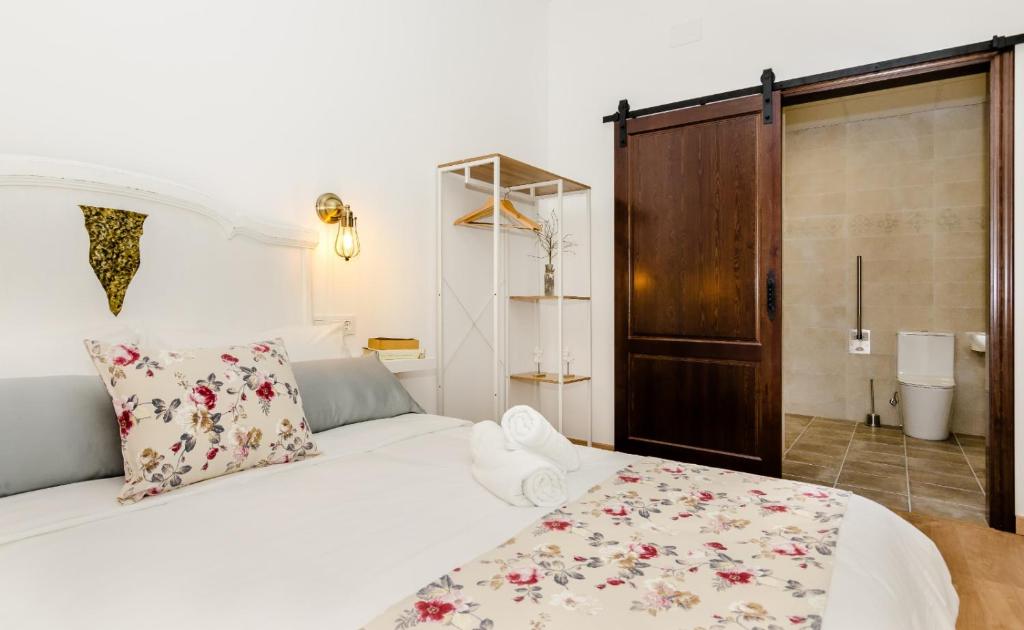 Un dormitorio con una gran cama blanca con flores. en PALACIO Boutique, en Anna