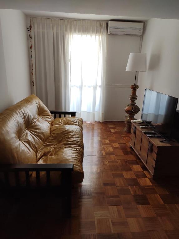 sala de estar con sofá y TV en Bubuhouse estadía mínima dos noches en Rosario